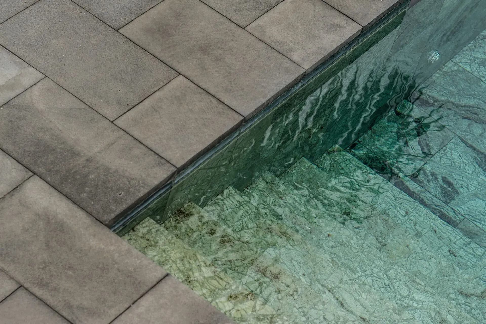 Piscina con revestimiento continuo de microcemento gris en una segunda residencia